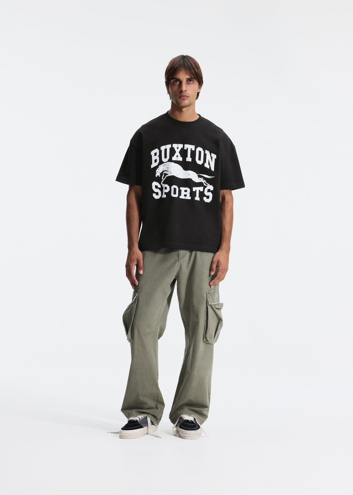 A black short-sleeve crewneck t-shirt featuring a white graphic print on the front that reads 'BUXTON SPORTS' with a horse silhouette, shown against a light gray background.