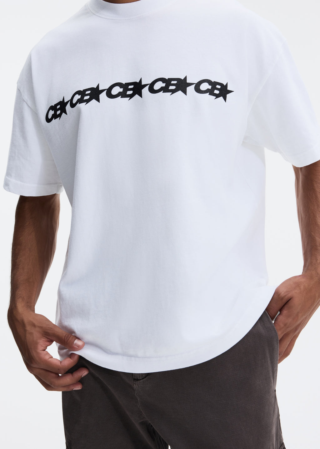 A white short-sleeve t-shirt with a black 'CE' star pattern repeated across the chest, worn by a model with dark gray pants against a light gray background.